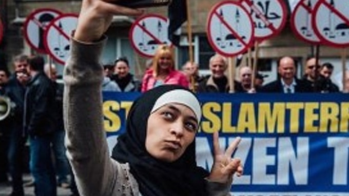 Muslim Woman Gleefully Trolls Anti Muslim Protesters With Viral Selfies (PHOTOS)